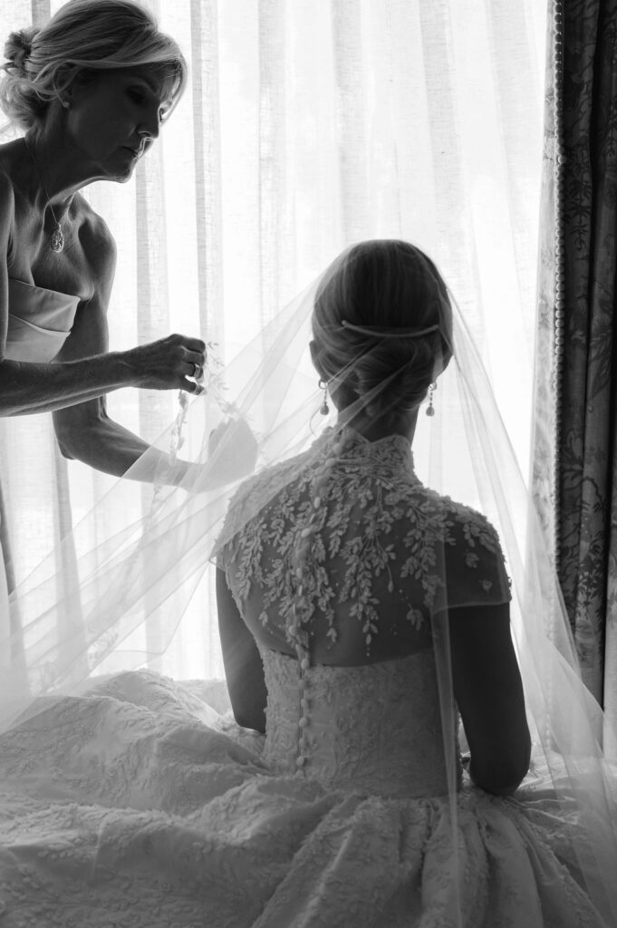 A Sea Island mother of the bride placing the brides veil.