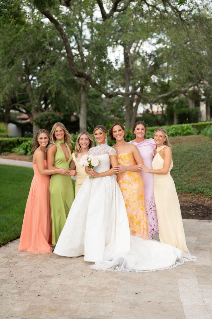 A Sea Island bride with her bridesmaids at the Cloister. The bridesmaids are wearing citrus-inspired, colorful gowns.