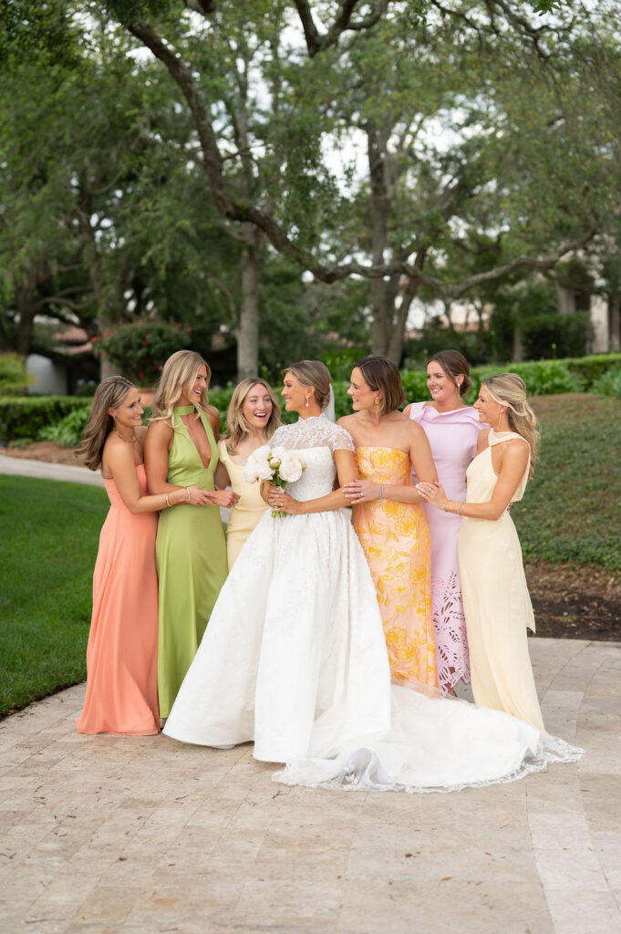 A Sea Island bride with her bridesmaids at the Cloister. The bridesmaids are wearing citrus-inspired, colorful gowns.