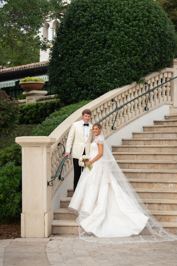 A Sea Island bride and groom standing on the stairs behind the Cloister.