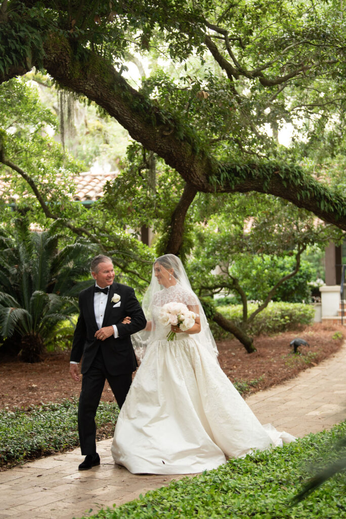 A Sea Island wedding, the father of the bride is walking her down the aisle to the Cloister Chapel.
