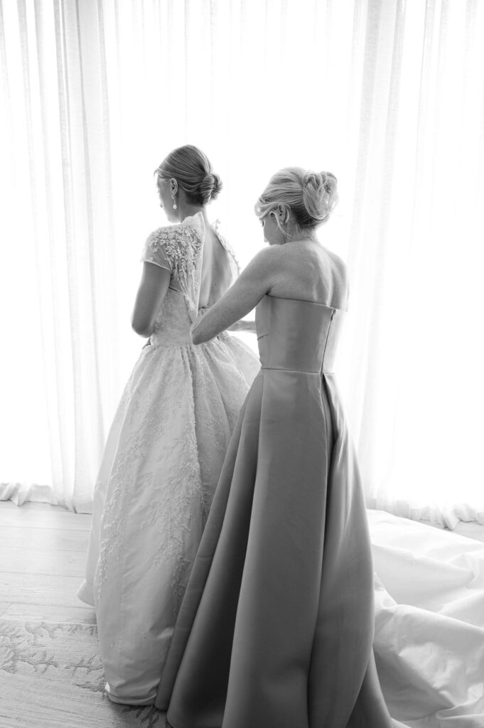 A Sea Island mother of the bride zipping her daughters bridal gown.