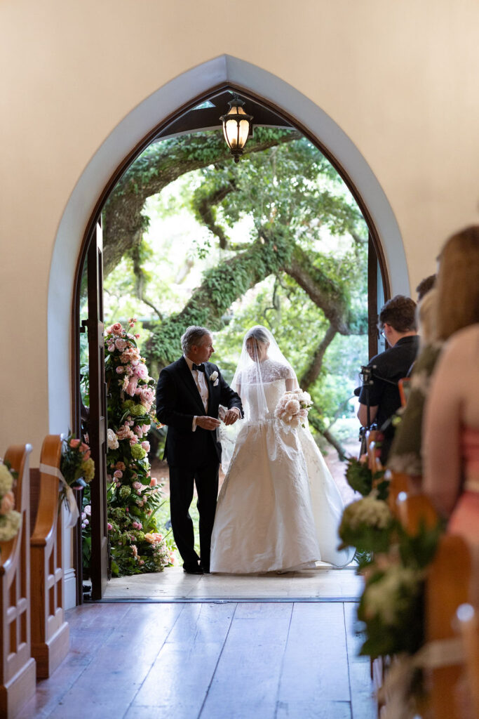 A Sea Island wedding, the father of the bride is walking her down the aisle to the Cloister Chapel.
